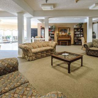 A cozy living room with patterned sofas, a coffee table, and bookshelves.