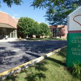 Entrance to a healthcare facility with visible signage and surrounding greenery.