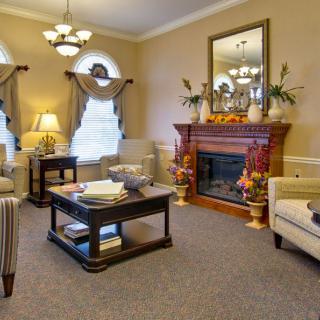 A cozy and elegantly designed living room featuring a fireplace, comfortable seating, and tasteful decor.