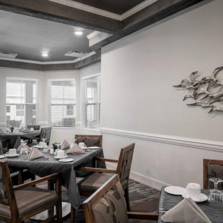 A cozy dining room with neatly set tables and elegant wall art.