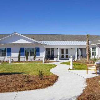 A single-story residential building with a well-maintained garden and a winding pathway.