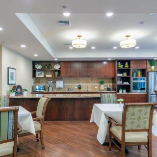 A modern kitchen and dining area with wooden cabinetry and elegant furniture.