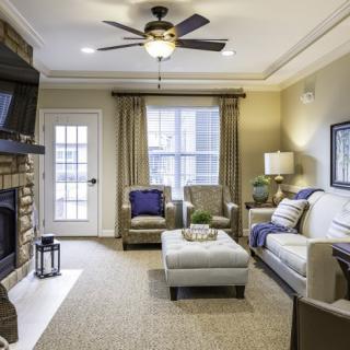 A cozy living room featuring a sofa, armchairs, and a fireplace.
