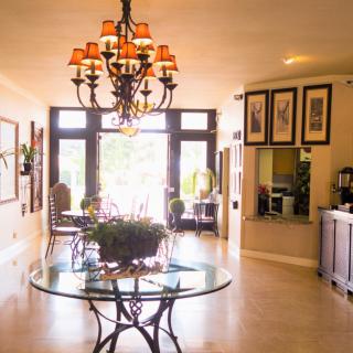 A well-lit lobby area with elegant decor and a central chandelier.