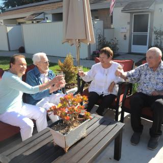 A group of seniors enjoying a sunny day together in the garden.