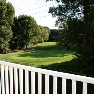 A scenic view of a golf course surrounded by lush trees.