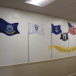 A wall display featuring various military and patriotic flags.