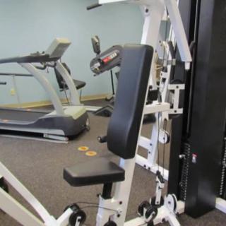 A fitness room featuring a treadmill and a multi-functional exercise machine.