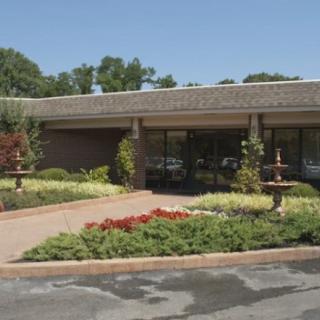 A single-story building with a landscaped entrance and garden.