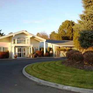 A suburban house with a curved driveway and well-maintained landscaping.