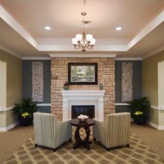 A cozy living room with a brick fireplace, two armchairs, and elegant decor.