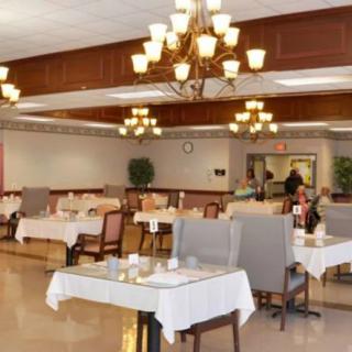 A spacious dining area with elegant chandeliers and neatly arranged tables.