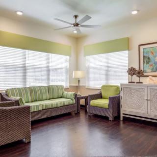 A cozy living room with modern furniture and a ceiling fan.