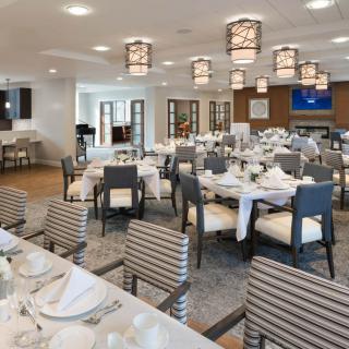 An elegant dining room with neatly arranged tables and chairs, soft lighting, and tasteful decor.