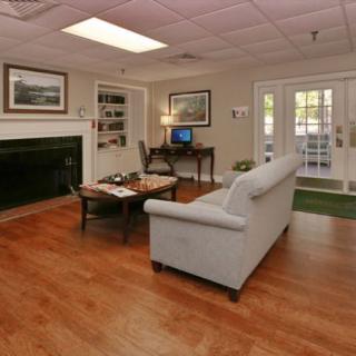 A cozy living room with a sofa, computer desk, and fireplace.