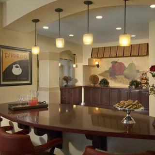 A modern kitchen with pendant lighting and a bar counter, featuring stylish artwork and seating.
