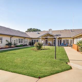 A well-maintained courtyard with a green lawn surrounded by a building.