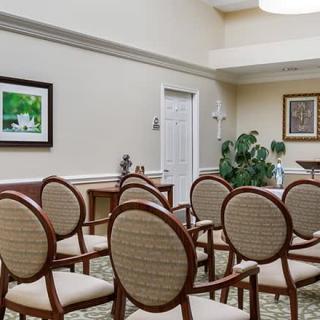 A small conference room with arranged chairs, artwork on the walls, and an indoor plant.