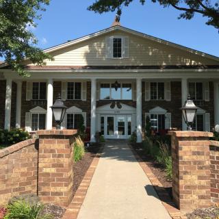 A grand building entrance with brick columns and a landscaped pathway.
