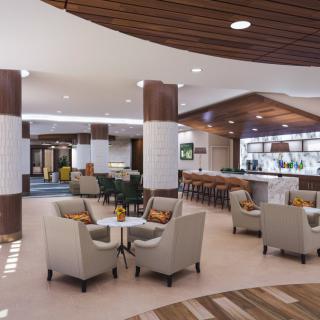 A modern lobby with comfortable seating and a bar area.
