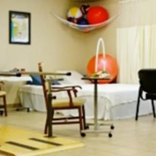 A physical therapy room equipped with exercise equipment and seating for rehabilitation sessions.