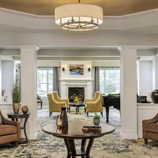 A cozy living room with elegant furniture and a central fireplace.