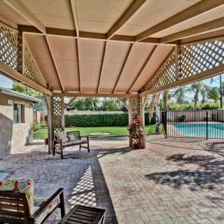 A spacious backyard patio with a pergola, outdoor seating, and a view of the swimming pool.