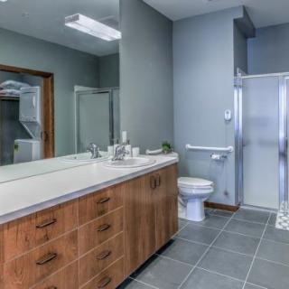 Modern bathroom with a large vanity, shower, and tiled floor.