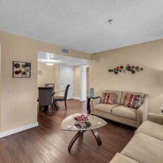 A modern living room with beige walls, featuring a sofa set and a stylish coffee table on hardwood floors.