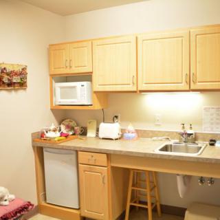 A compact kitchen with wooden cabinets, a microwave, and a sink area.