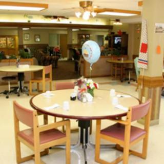 A cozy dining area with a round table, chairs, and a balloon decoration.