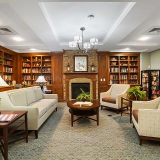 Cozy library with plush seating and a warm fireplace.