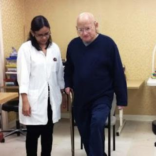 An elderly man undergoing physiotherapy with a healthcare professional.