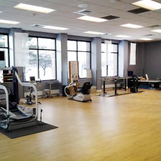 A spacious fitness studio equipped with various exercise machines and plenty of natural light.