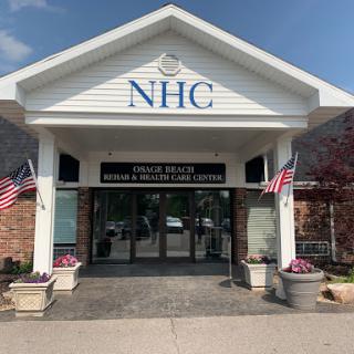 Main entrance of the NHC healthcare facility decorated with American flags.