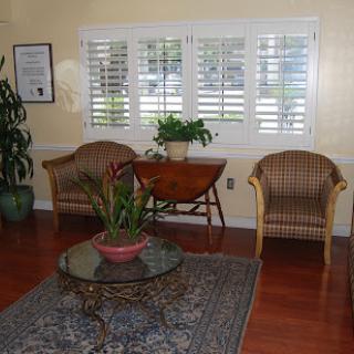 A cozy waiting area featuring comfortable chairs, a decorative table, and houseplants.