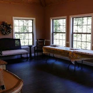 A bright, inviting interior space featuring multiple windows, a seating area, and a table.