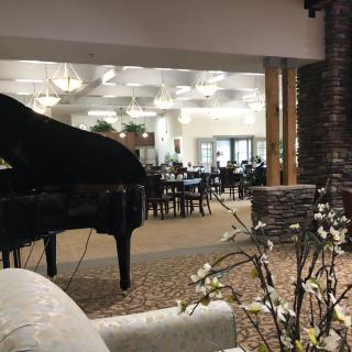 Elegant restaurant interior with a grand piano and floral decor.