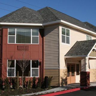 A modern residential building with mixed siding and multiple windows.