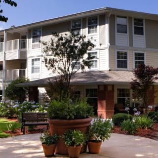 A well-maintained residential apartment building surrounded by lush gardens.