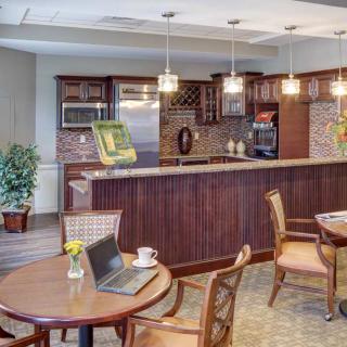 A modern kitchen and cafe area with wooden furniture and contemporary lighting.