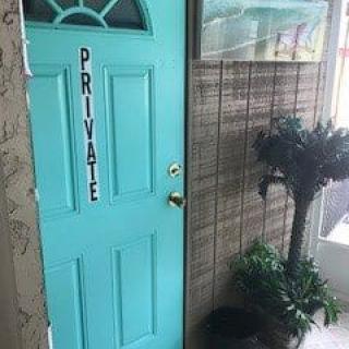 A turquoise door labeled 'Private' next to some indoor plants.