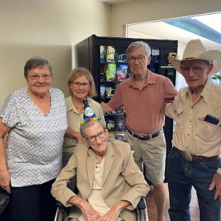 A joyful family gathering with an elderly member in a wheelchair.