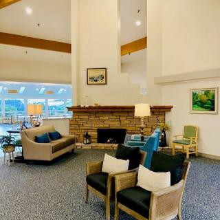 A cozy living room interior featuring a seating area around a fireplace with modern furnishings and decor.