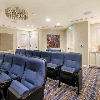 A cozy home theater room with rows of blue seating and modern decor.