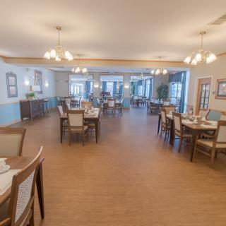 A spacious and elegantly designed dining area with arranged tables and chairs, ready for guests.