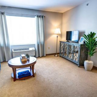 A cozy living room featuring a coffee table, TV stand, and floor lamp with modern decor.