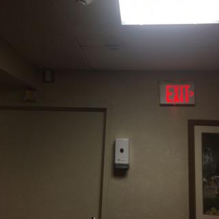 Interior view featuring an illuminated exit sign above a door.
