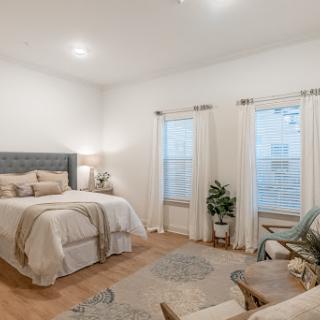 A cozy and modern bedroom featuring a comfortable bed, stylish furnishings, and ample natural light.