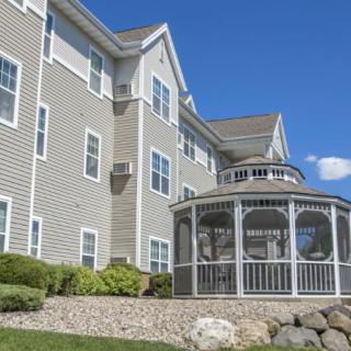A residential building with a white gazebo under a clear blue sky.
